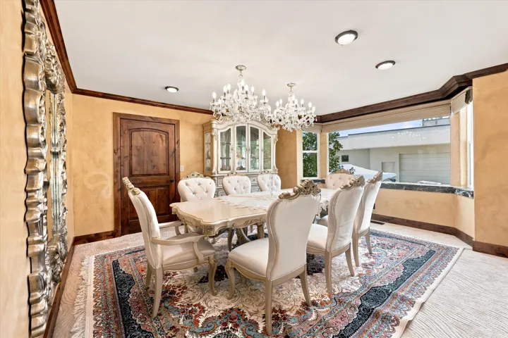 Recessed lighting, ornamental chandelier, wood-finish flooring, and a built-in display cabinet