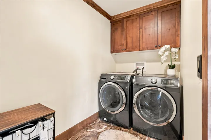 Wood-finish cabinetry, wood trim accents, and stone-look tile flooring