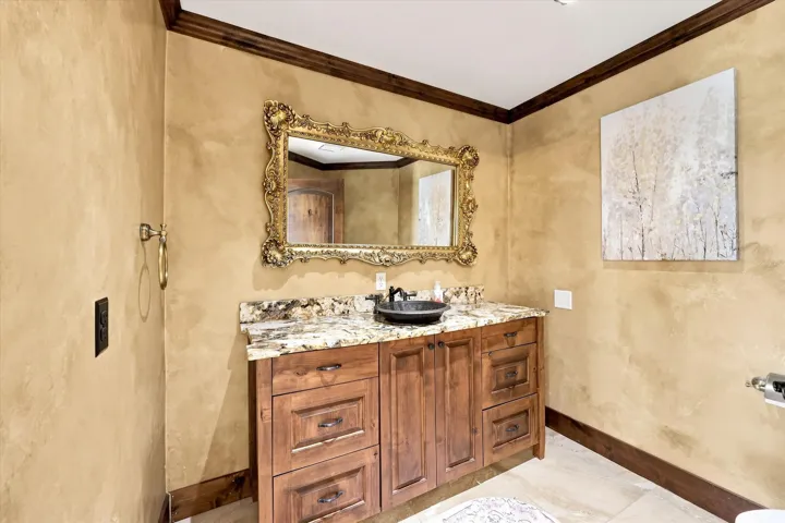 Wood vanity with stone countertop and vessel sink