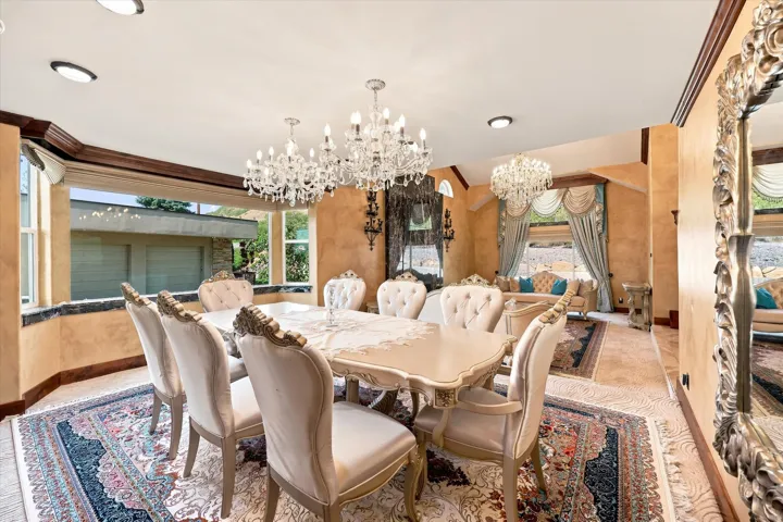 Recessed ceiling lighting, ornate crystal chandeliers, large picture windows, wood-finish window trim, and decorative wall sconces