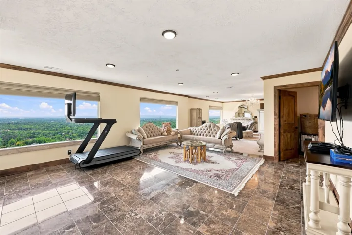 Expansive room with large windows, recessed lighting, wood trim, and polished tile flooring