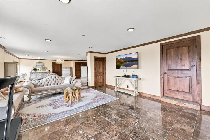 Recessed lighting, wood-finish trim, solid wood doors, and polished stone tile flooring throughout