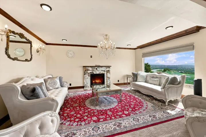Expansive living area featuring a stone-clad fireplace, recessed lighting, and a large picture window with valley views