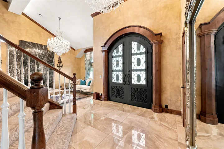 Arched double entry doors with decorative ironwork, framed by wood-finish trim and columns