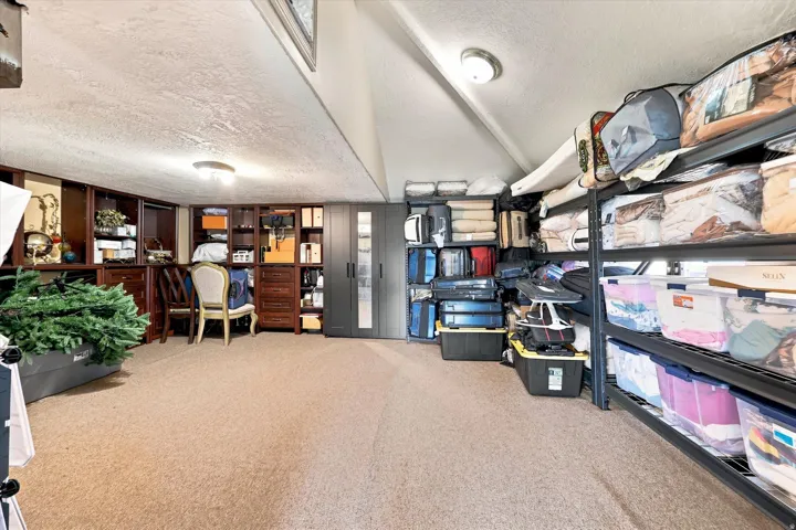 Carpeted flooring with sloped ceilings, recessed lighting, and built-in wood cabinetry