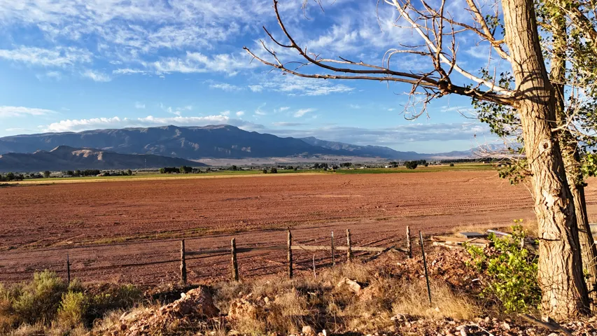 Expansive land offering diverse topography, mature trees, and distant mountain ranges