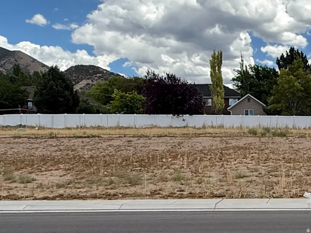 Expansive lot featuring a level grade, paved street frontage, and a white perimeter fence