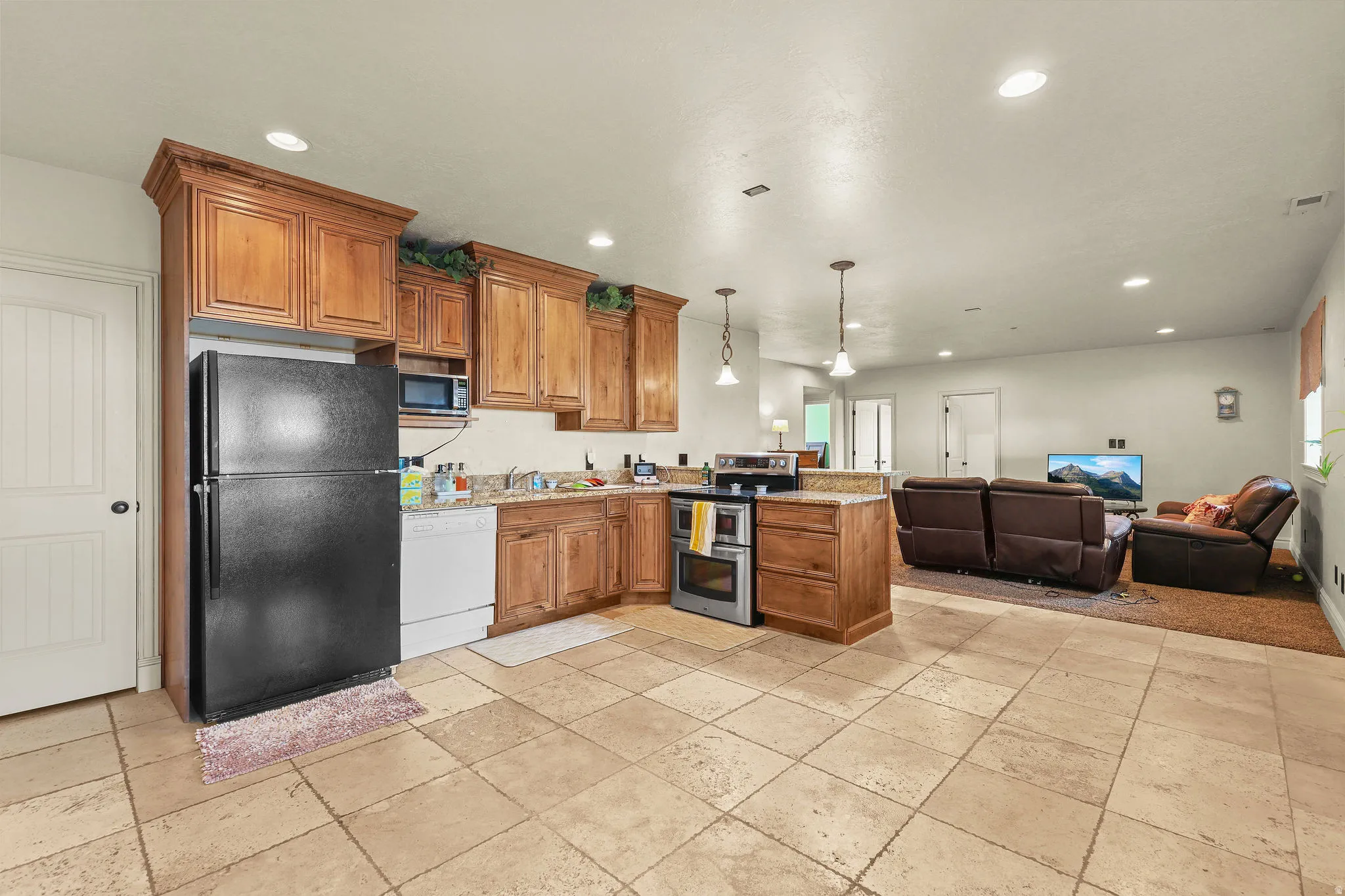 Kitchen featuring wood-finish cabinetry, stainless steel appliances, and a tiled backsplash
