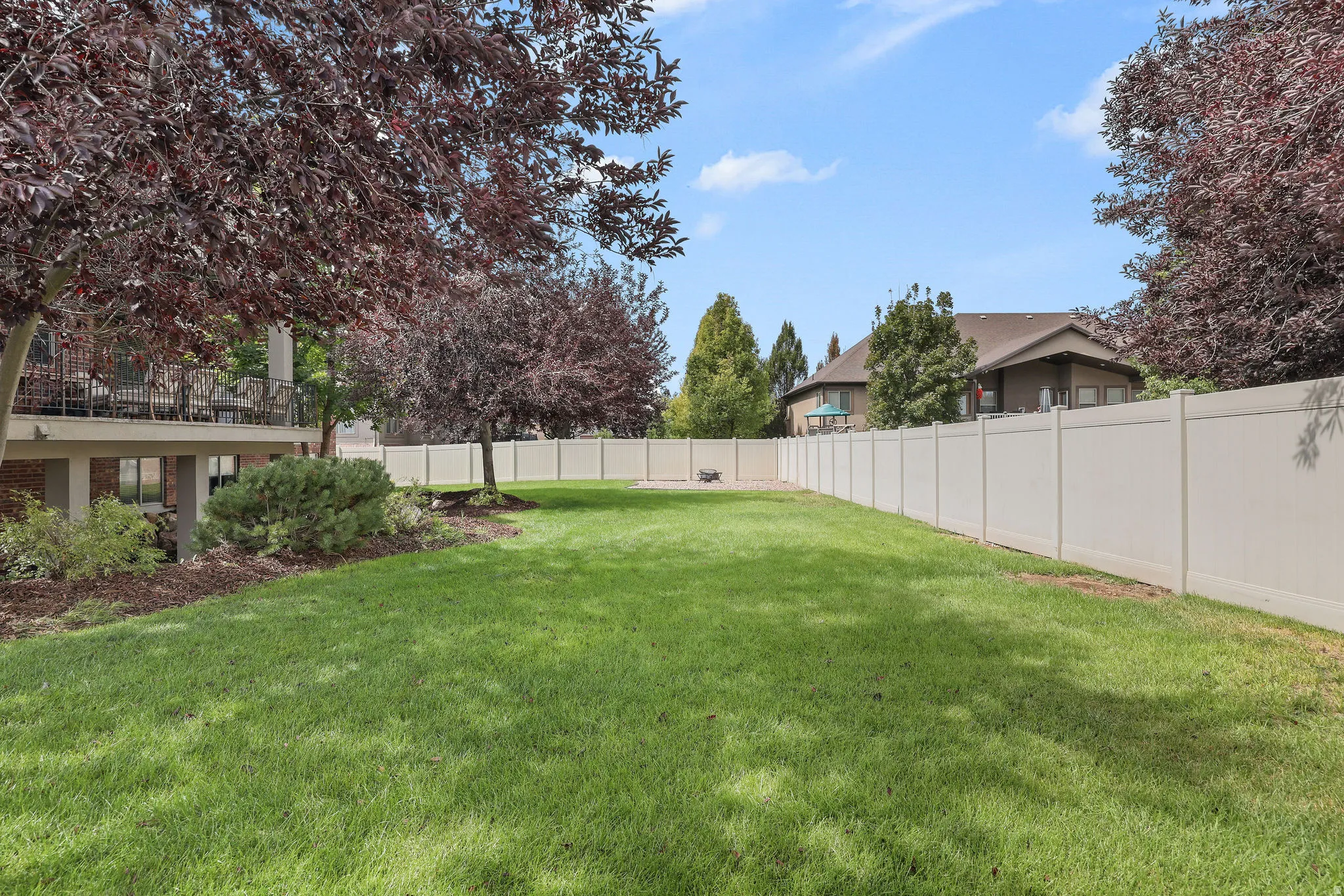 Expansive green lawn framed by a tall privacy fence