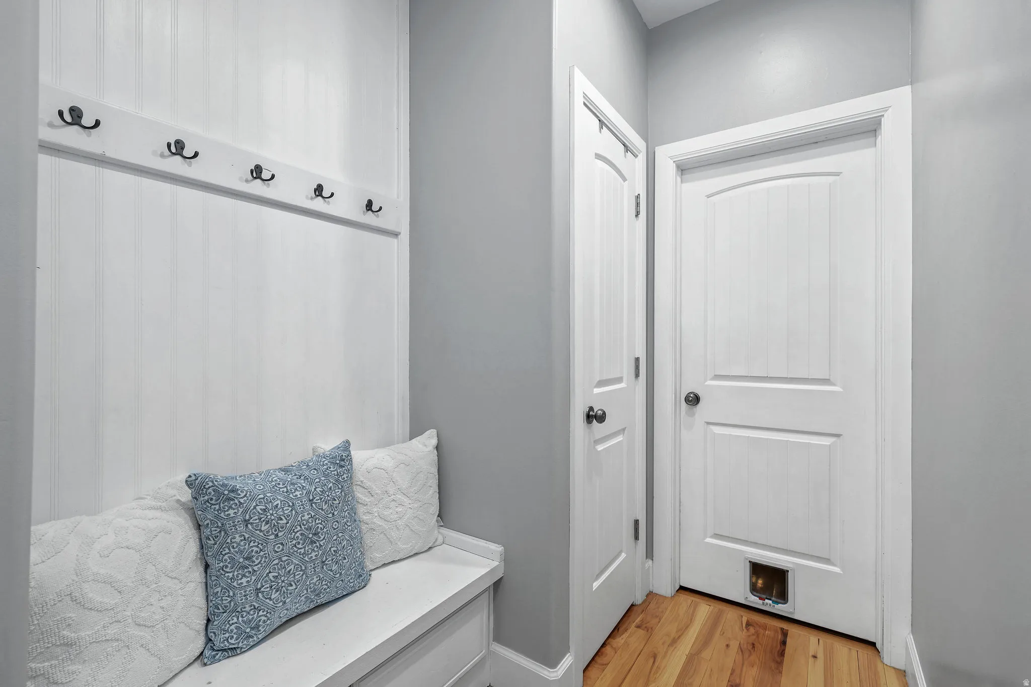 Built-in bench with beadboard wainscoting and coat hooks