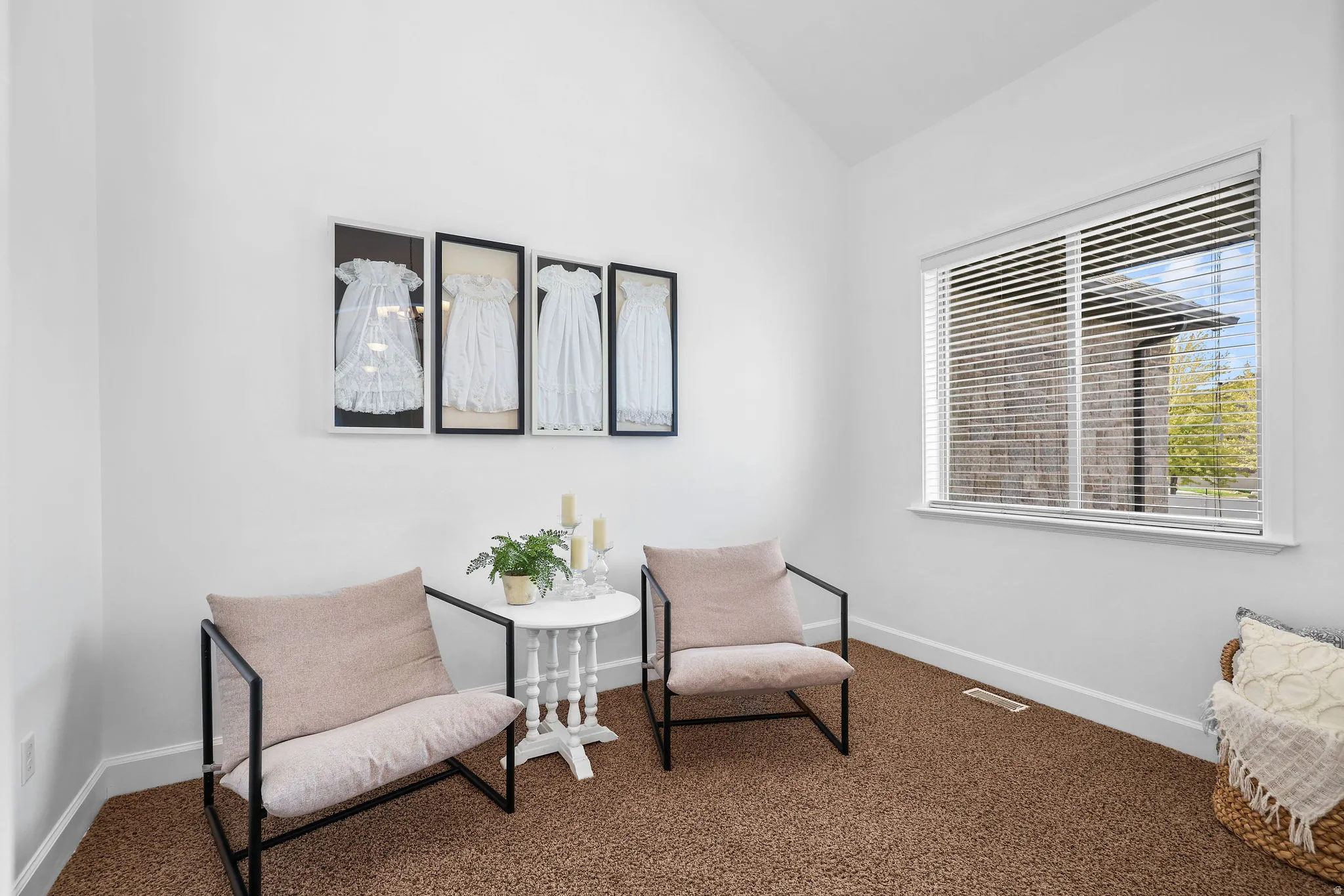 Vaulted ceiling, white walls, large window with blinds, and brown carpet flooring