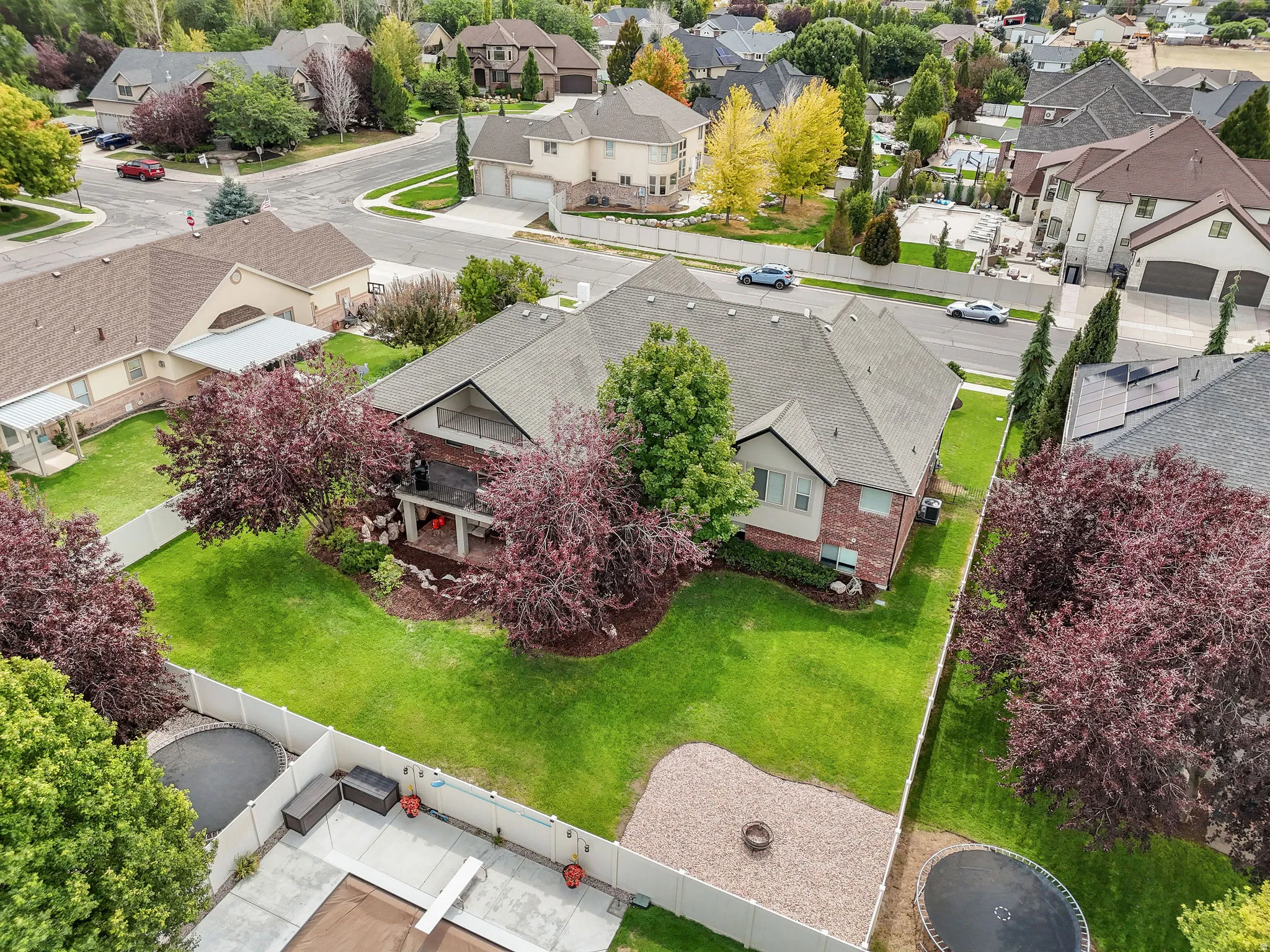 Brick exterior with an upper-level balcony, complemented by a gabled roofline and an expansive manicured lawn