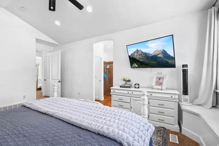 Vaulted ceiling with recessed lighting, wood-finish flooring, and a built-in window seat