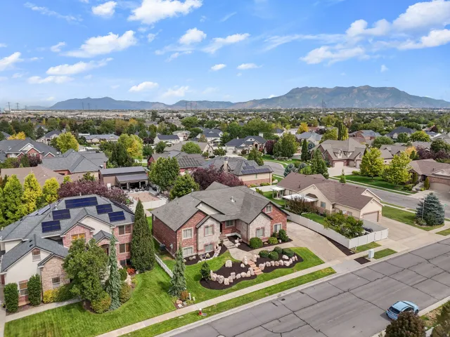 Brick exterior with stone accents, mature landscaping, paved driveway, and established neighborhood setting