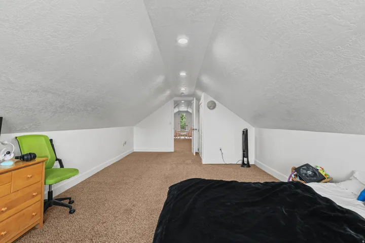 Carpeted flooring with recessed lighting, an angled ceiling, and white painted walls