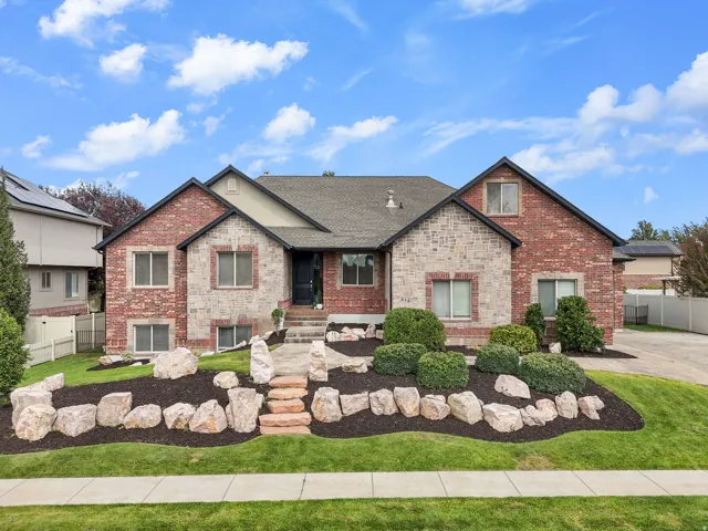 Brick and stone facade with a dark shingled roof