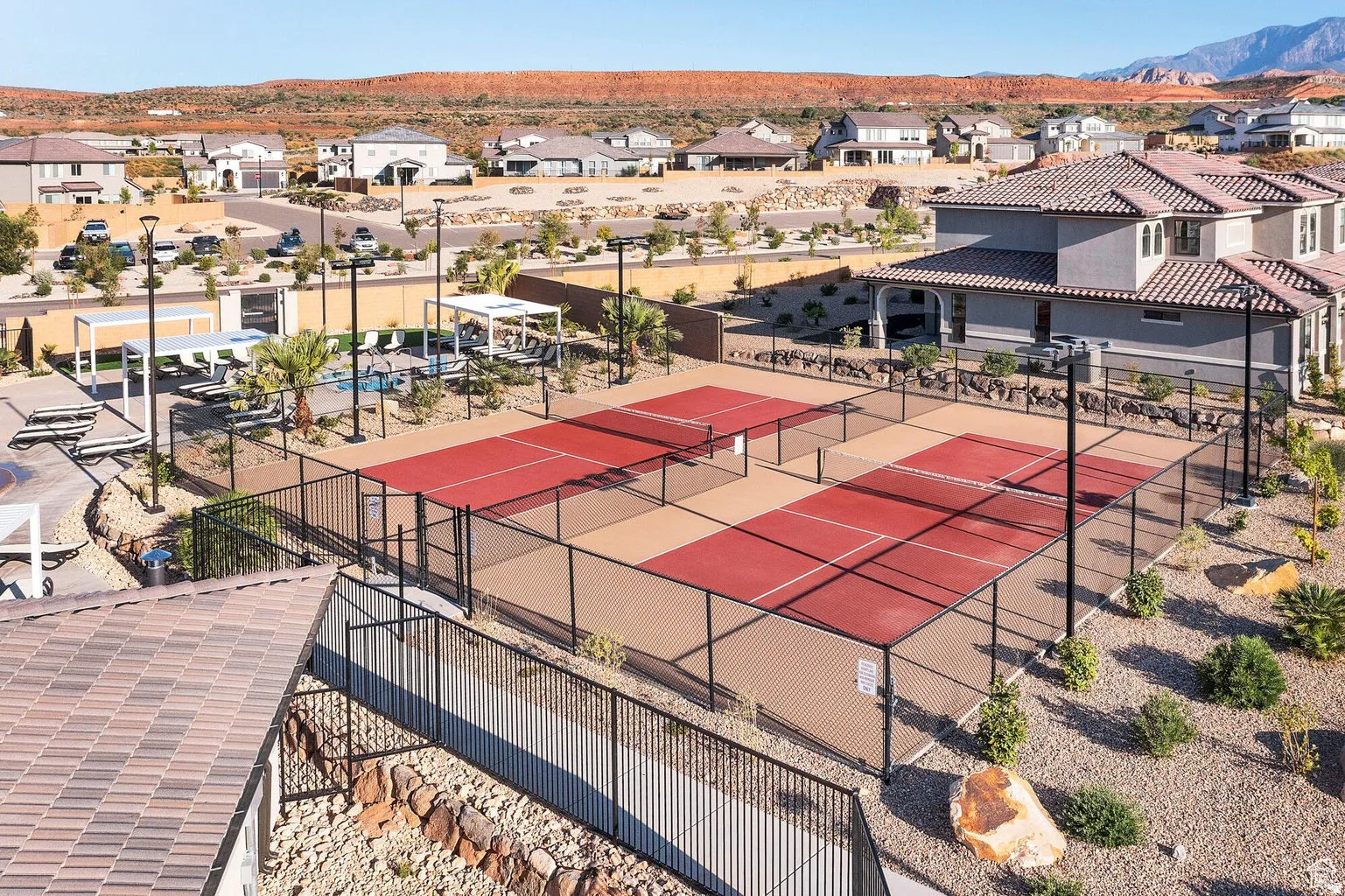 Multiple fenced pickleball courts, swimming pool, and cabanas