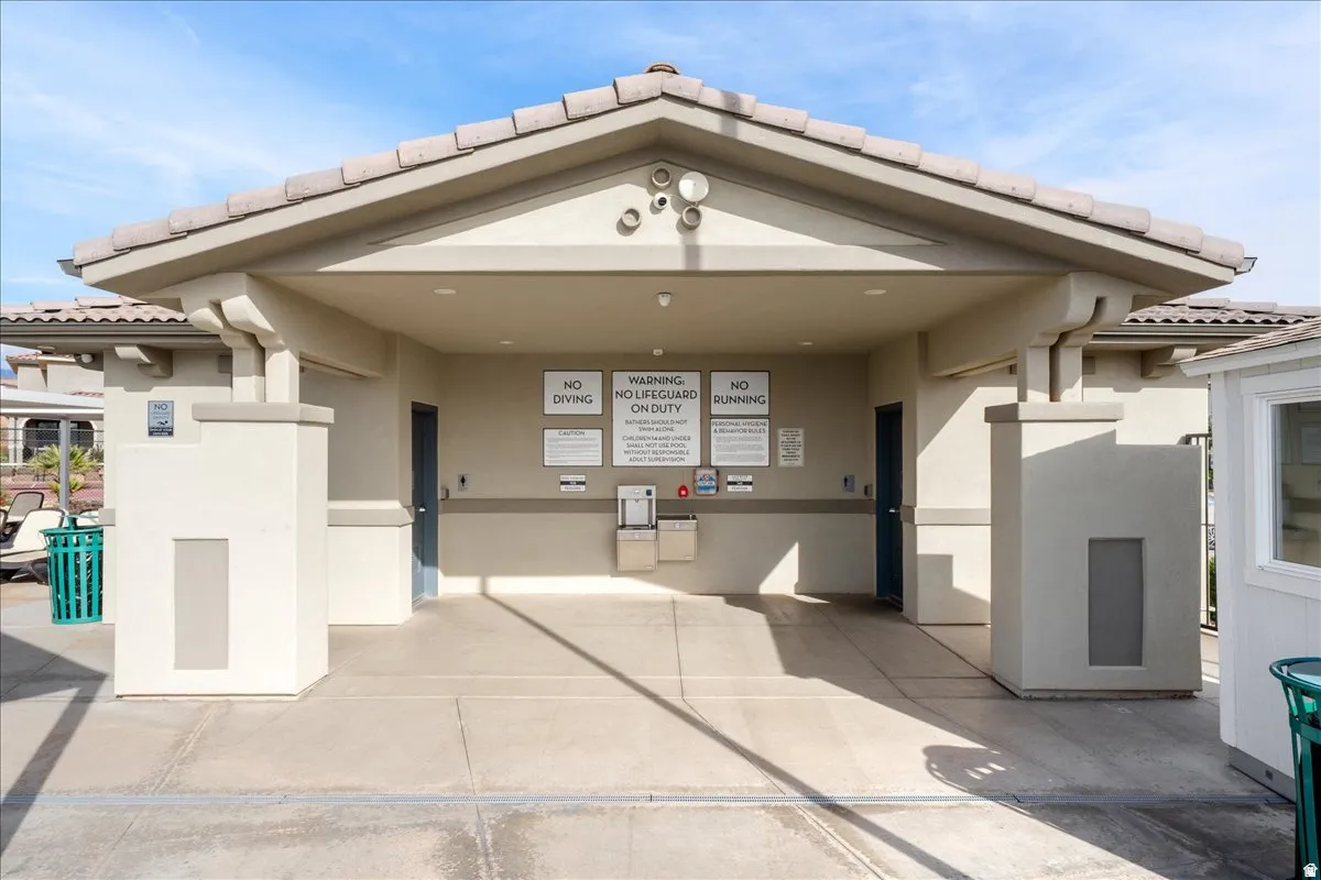 Covered entry structure with a tiled roof, stucco exterior, and concrete flooring