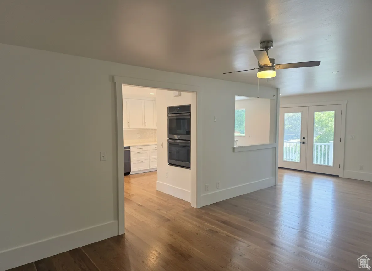 Hardwood flooring throughout, recessed lighting, and a ceiling fan with integrated lighting