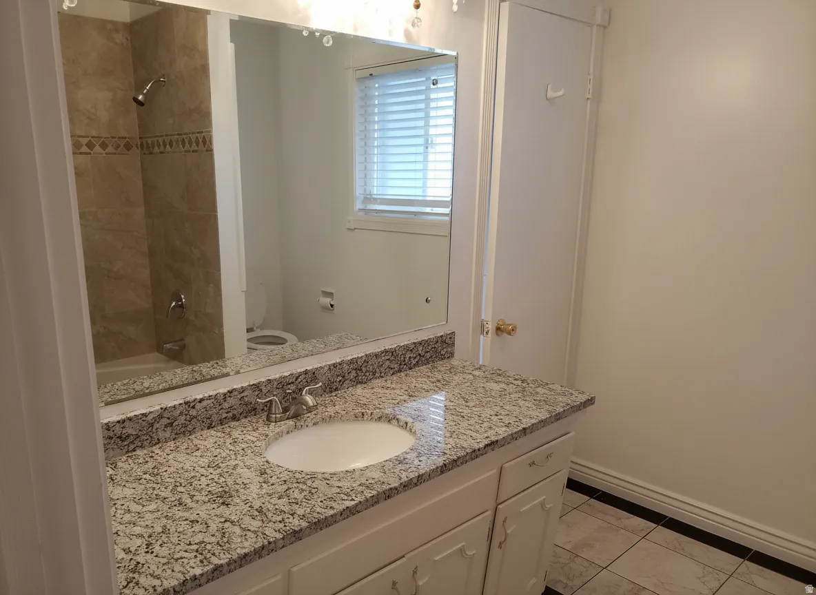 Vanity with an integrated sink, granite-style countertop, and chrome faucet