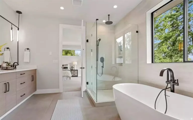 Freestanding soaking tub with a floor-mounted matte black faucet