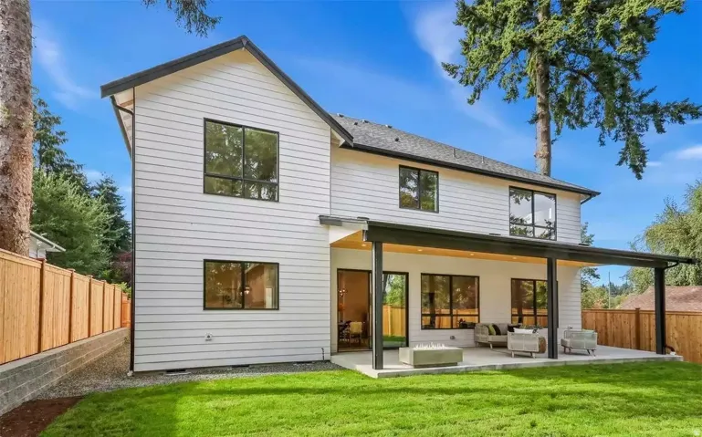 Contemporary two-story residence with white horizontal siding and black trim accents