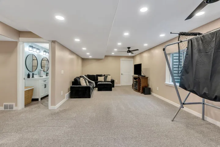 Recessed lighting, light-colored walls, and carpet flooring