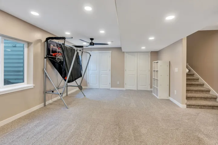 Spacious room featuring neutral carpeting, recessed lighting, a ceiling fan, and white trim
