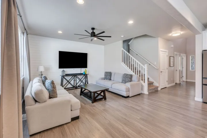Open-concept living area featuring wood-finish flooring, recessed lighting, and a modern ceiling fan