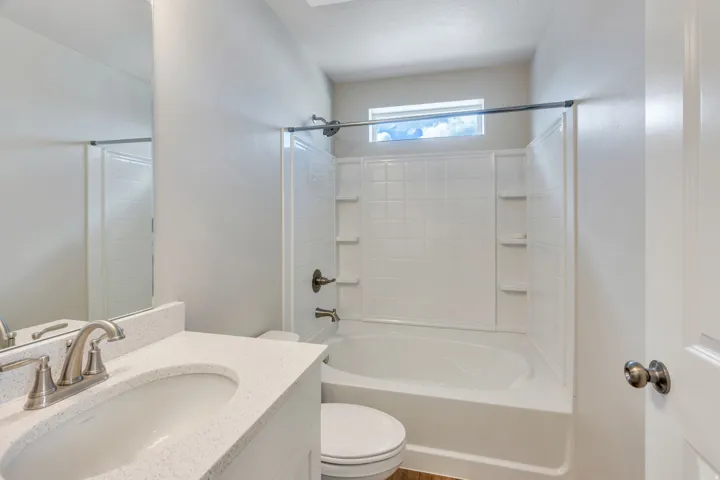 Bathroom featuring a white vanity with an integrated sink, brushed nickel faucet, and a large mirror