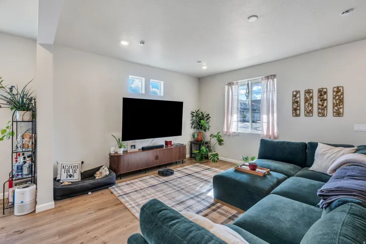 Living area featuring wood-finish flooring, recessed lighting, and large windows