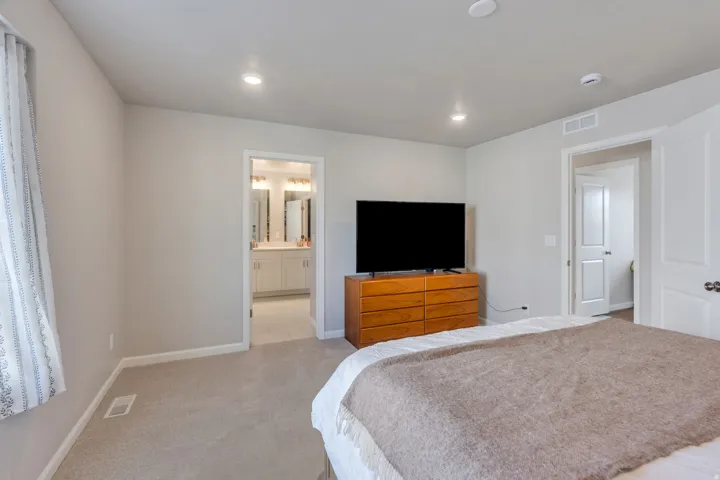 Recessed lighting, light gray wall finish, neutral carpet flooring, and white trim throughout