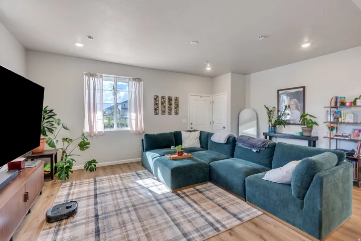 Recessed ceiling lighting, wood-finish flooring, and white interior doors