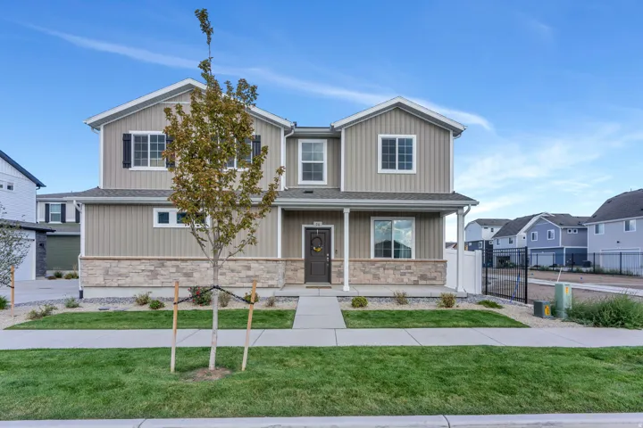 Modern two-story residence featuring a taupe and gray vertical siding exterior with peaked rooflines and multiple windows