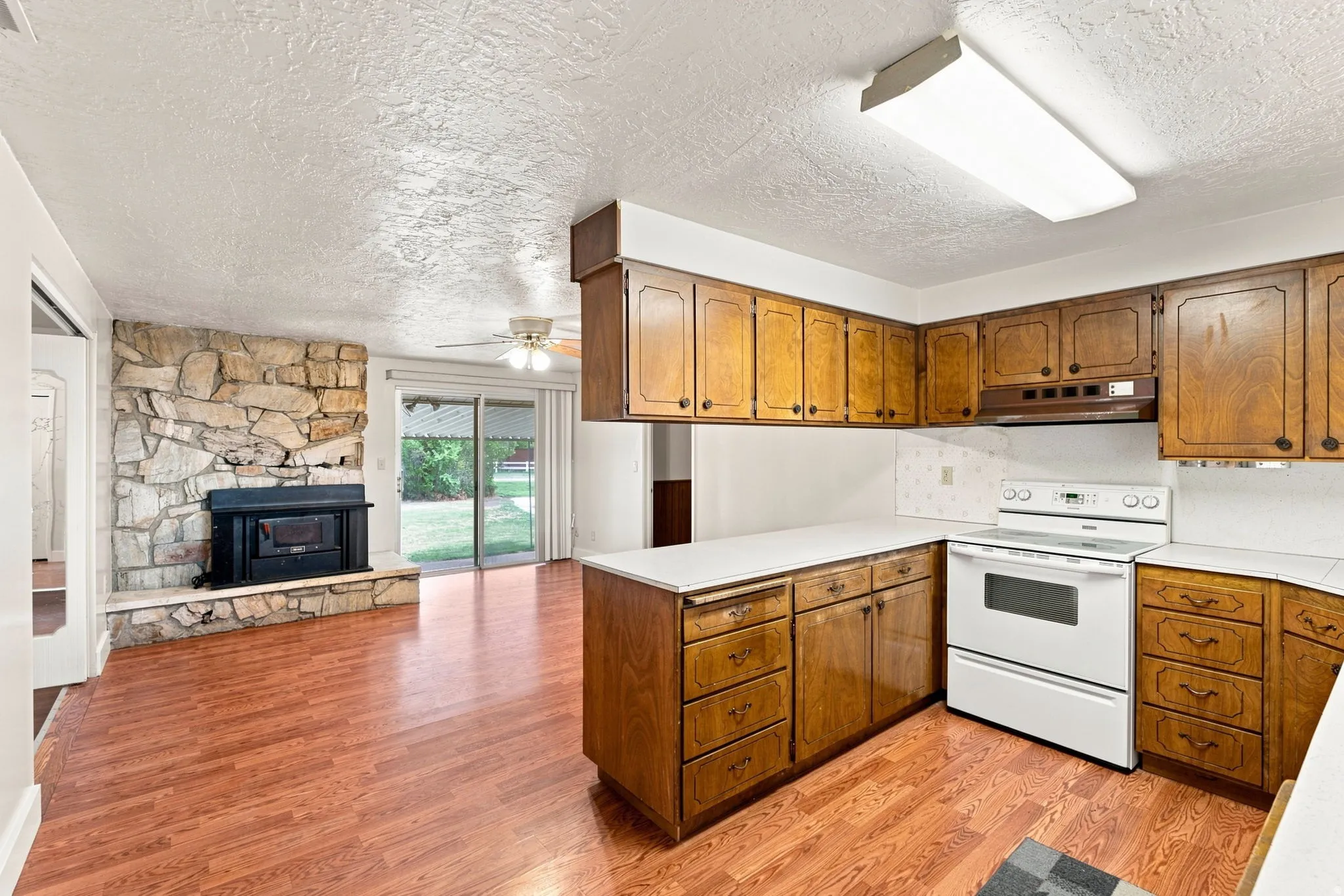 Kitchen featuring wood-finish flooring, wood cabinetry, white countertops, and a full-size range