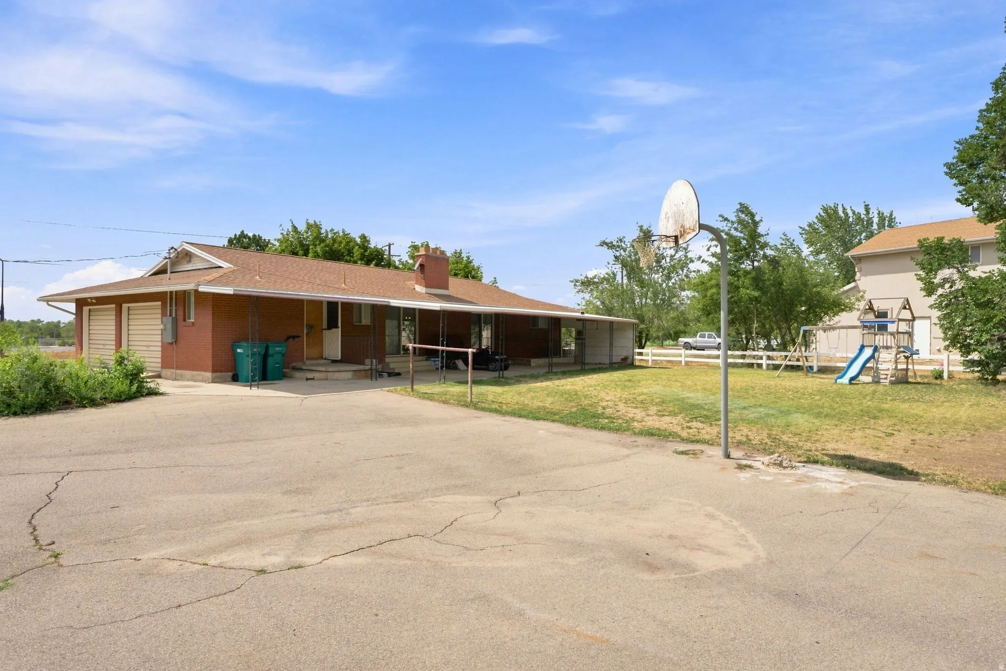 Brick exterior ranch home featuring an attached two-car garage, covered patio, and concrete driveway
