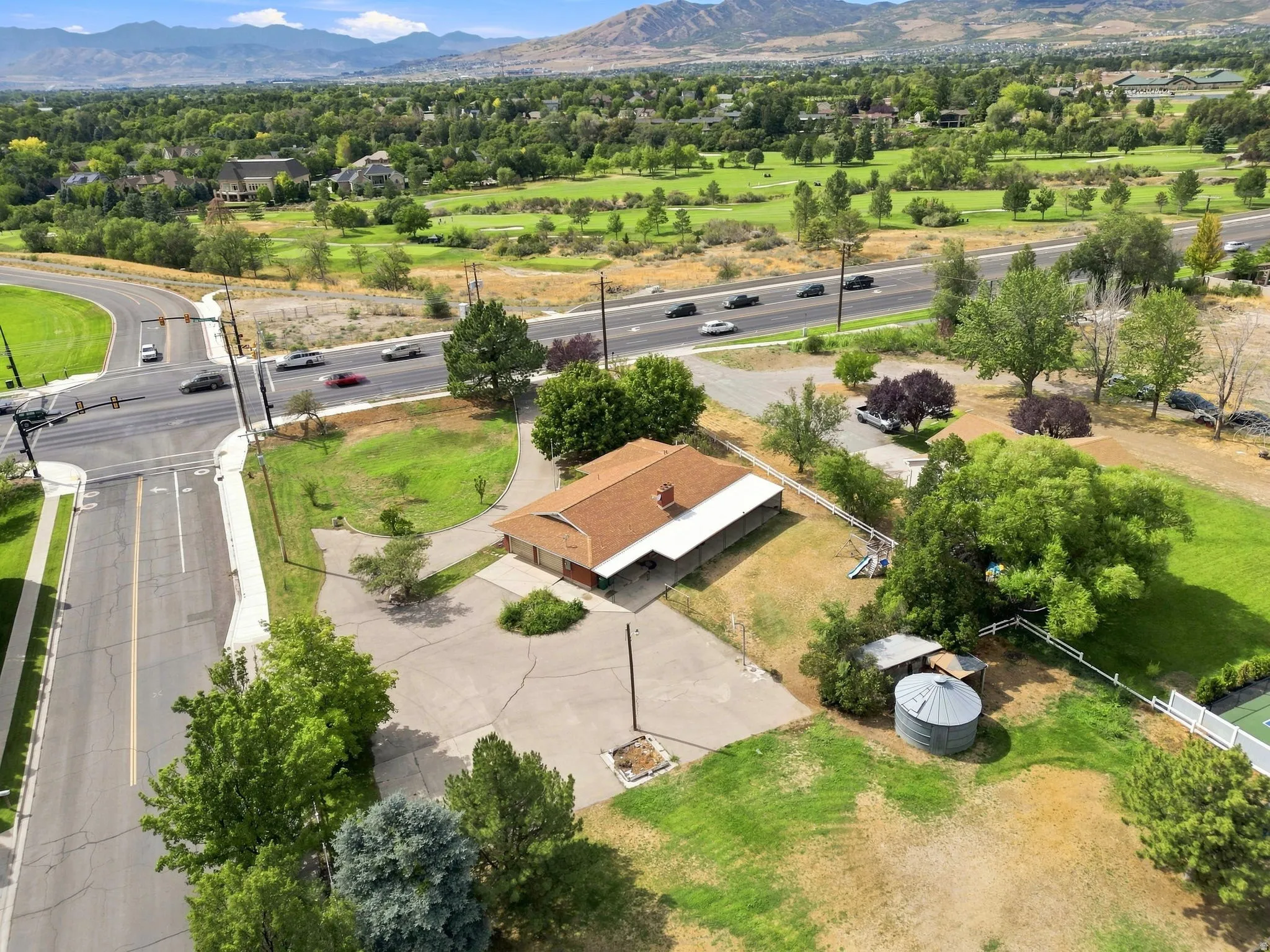Single-story residence with an attached garage, substantial paved driveway, and a shingle roof