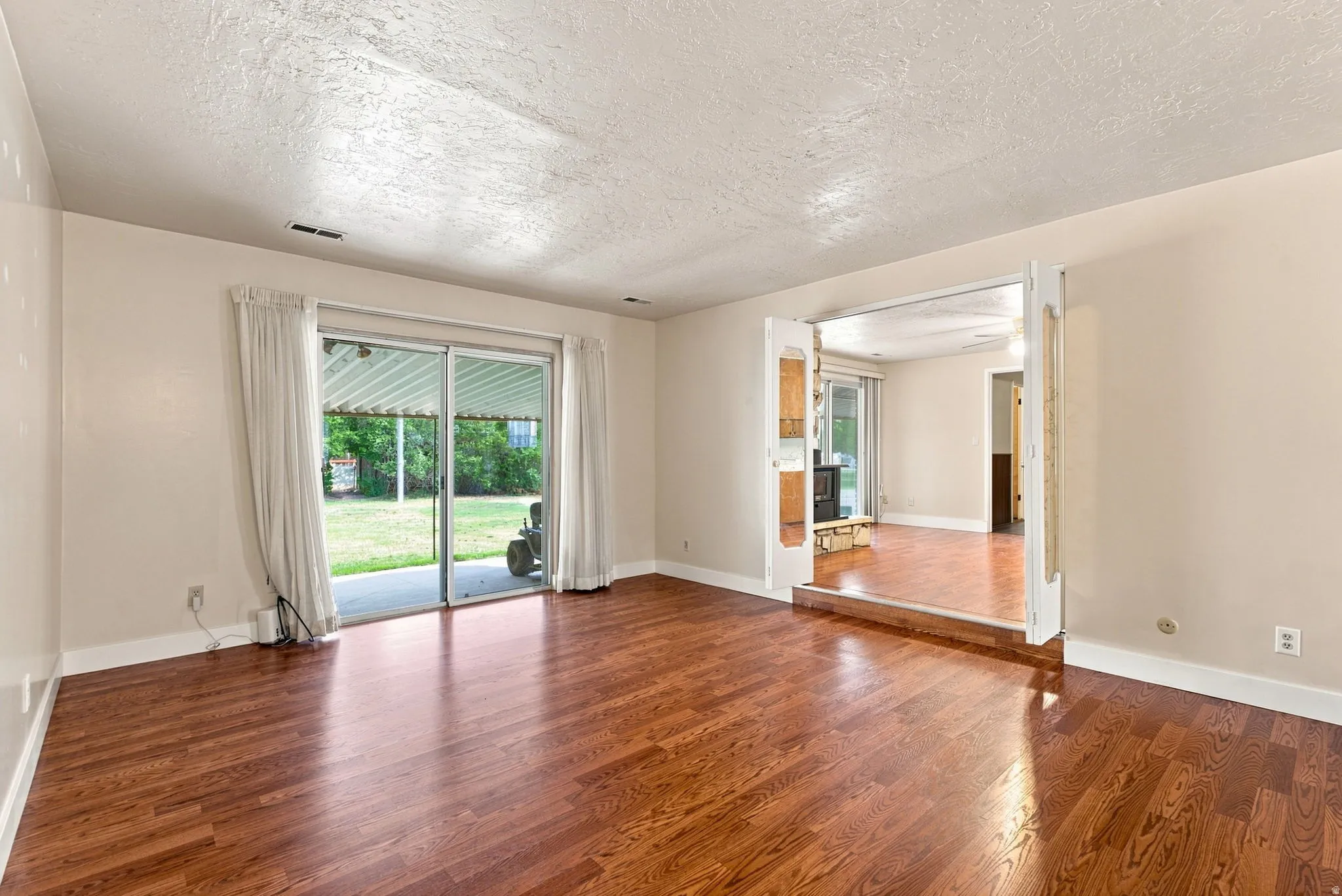 Wood-finish flooring throughout, with sliding glass doors opening to a covered patio