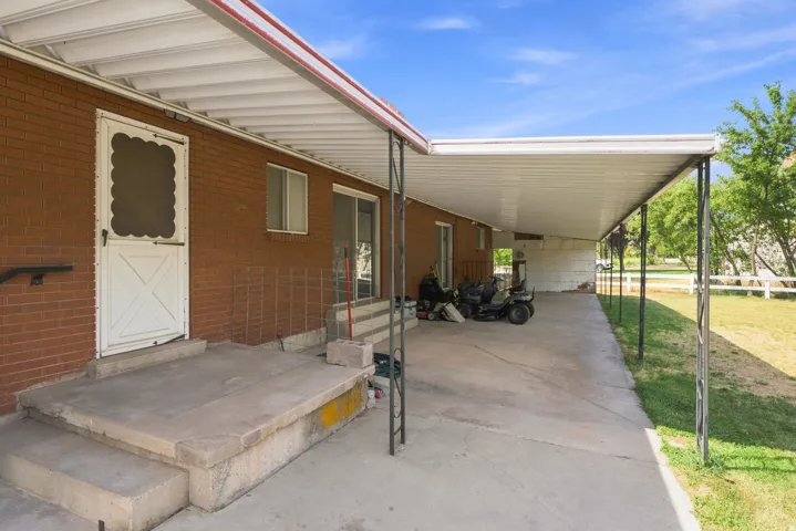 Brick exterior with an expansive covered patio, concrete flooring, and a sliding glass door