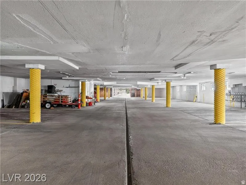 Concrete flooring with yellow spiral column protectors and exposed concrete ceiling