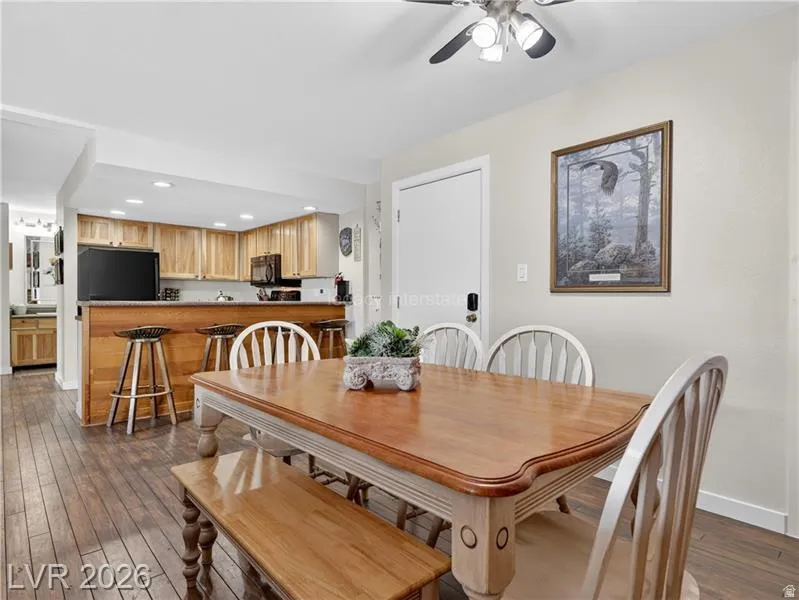 Wood-finish flooring throughout, with a ceiling fan featuring integrated lighting