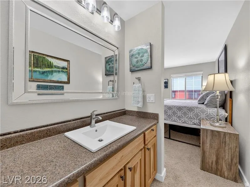 Bathroom vanity with a rectangular undermount sink, wood-finish cabinetry, and a textured countertop