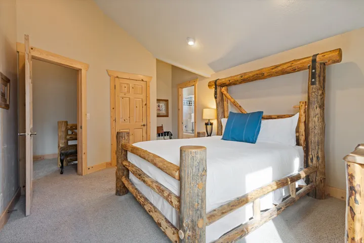 Vaulted ceiling, recessed lighting, neutral wall color, light-toned carpeting, and wood-paneled doors