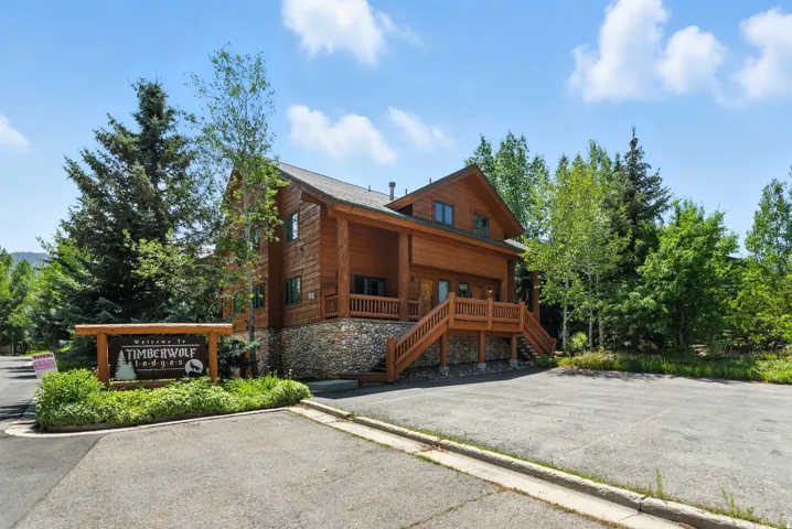 Log-sided exterior with stone foundation, multiple balconies, and a gabled roof