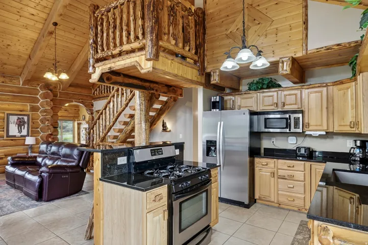 Open-concept living space with log cabin construction and exposed wood beams