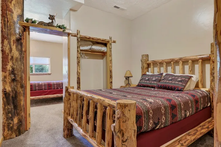 Rustic wood-frame bed with a coordinating wood-frame clothing rack