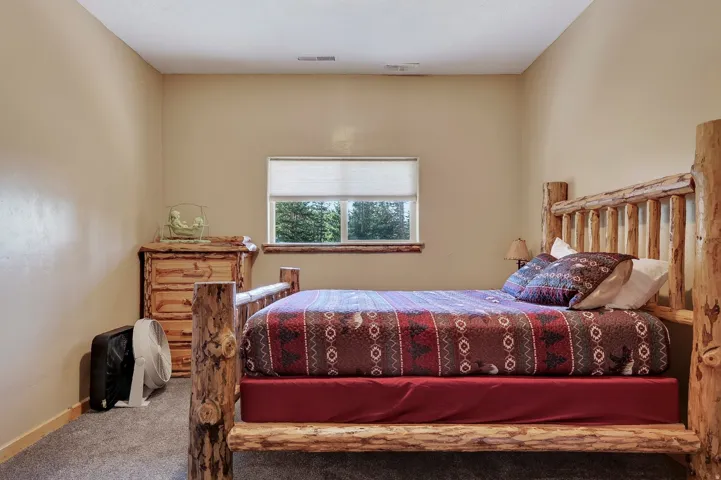 Carpeted flooring, window with roller shade, wood-finish window trim, and neutral wall paint