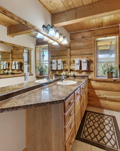 Dual vanity with integrated sinks, wood cabinetry, and a speckled countertop