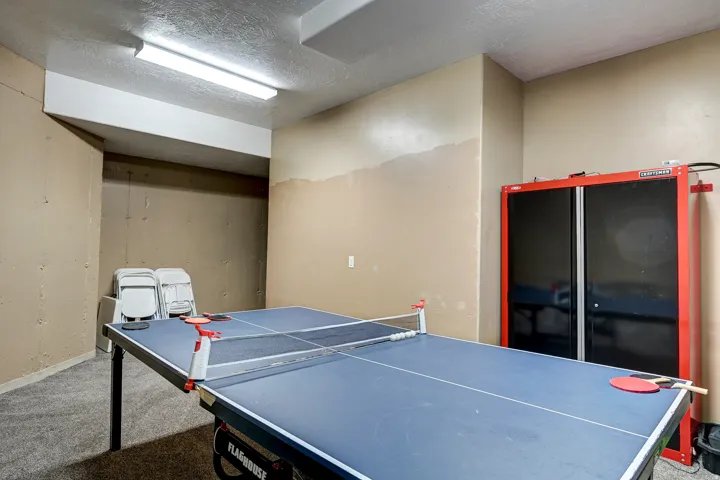 Fluorescent overhead lighting illuminates a room with light beige walls and textured ceiling