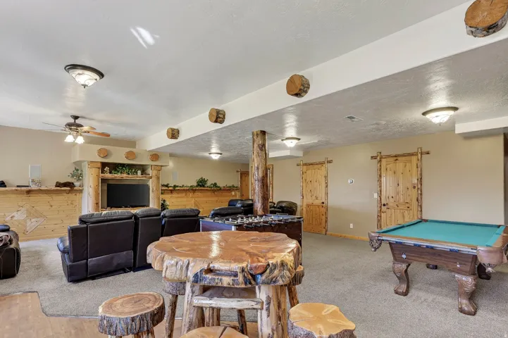 Spacious entertainment area with textured wall finishes, recessed lighting, and wood-finish doors